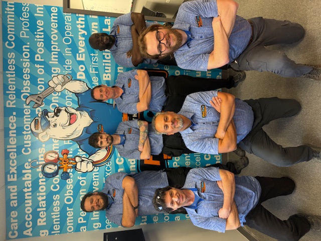 Male members of First Care team kneeling in front of a wall with their values
