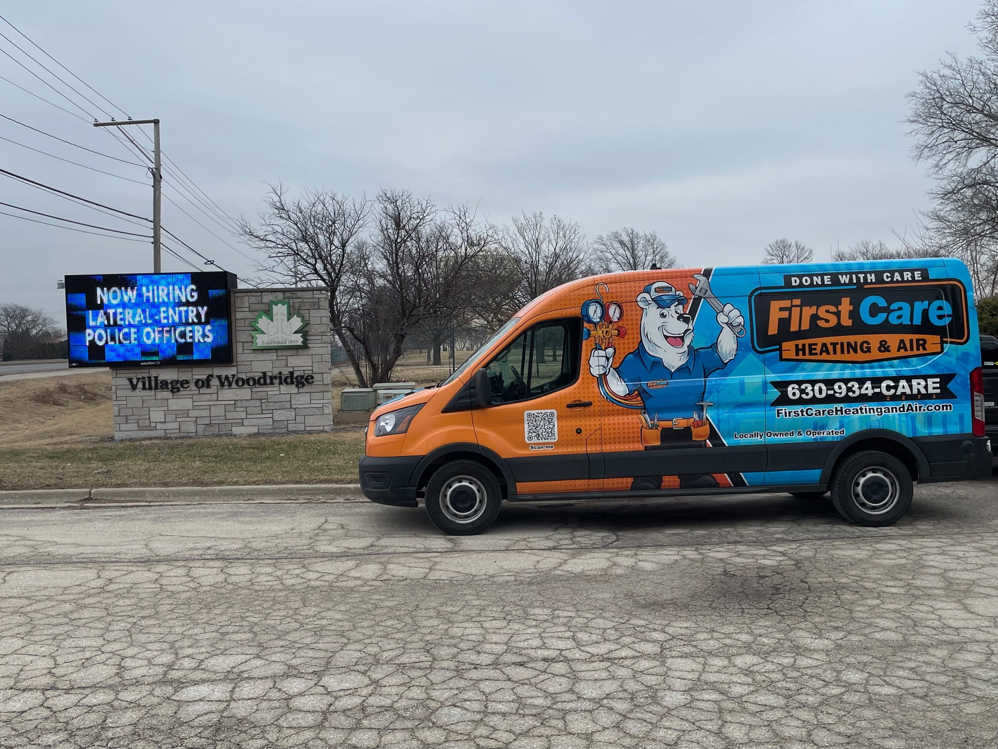 A First Care van by the Village of Woodridge Welcome sign